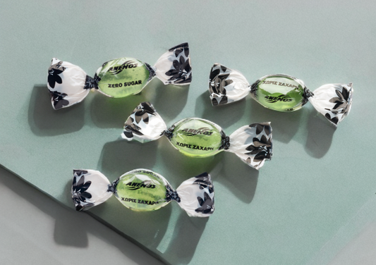 Mastic gum candies Anemos with green labels on a light blue background